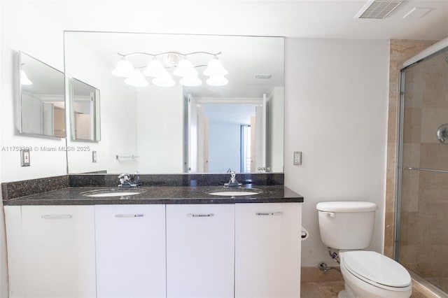 full bathroom featuring toilet, a stall shower, visible vents, and a sink