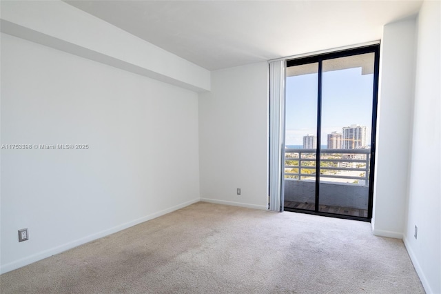 carpeted spare room with a view of city, floor to ceiling windows, and baseboards