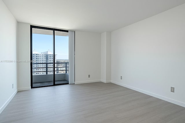 3300 NE 192nd St Unit 1908, Aventura, FL 33180 - unfurnished room featuring baseboards, floor to ceiling windows, and light wood-style floors