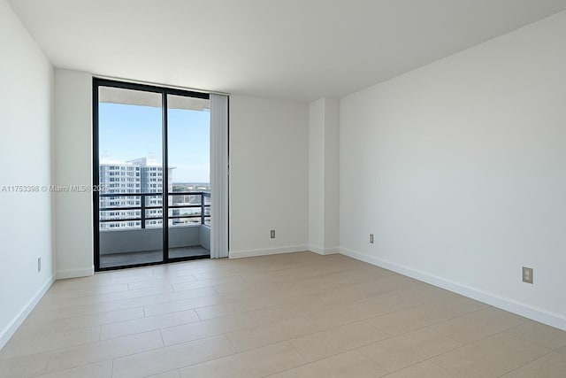 3300 NE 192nd St Unit 1908, Aventura, FL 33180 - unfurnished room with baseboards and a wall of windows
