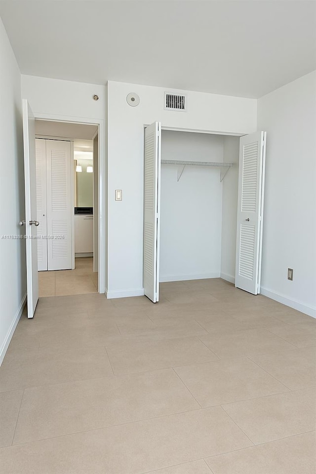 3300 NE 192nd St Unit 1908, Aventura, FL 33180 - unfurnished bedroom with visible vents, baseboards, light tile patterned flooring, and a closet