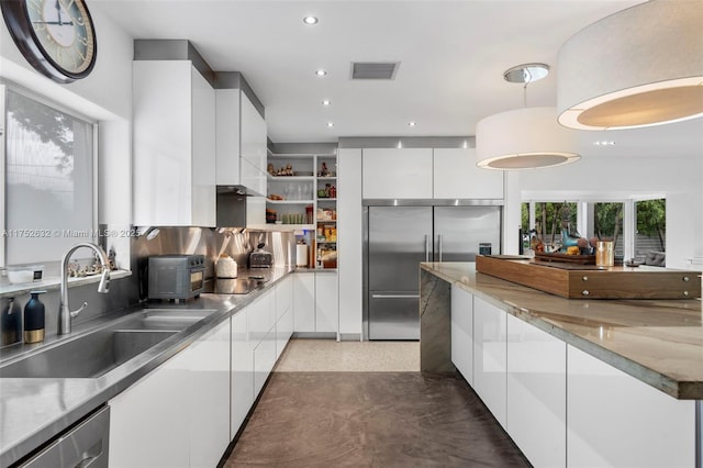 kitchen featuring visible vents, modern cabinets, stainless steel appliances, white cabinetry, and a sink