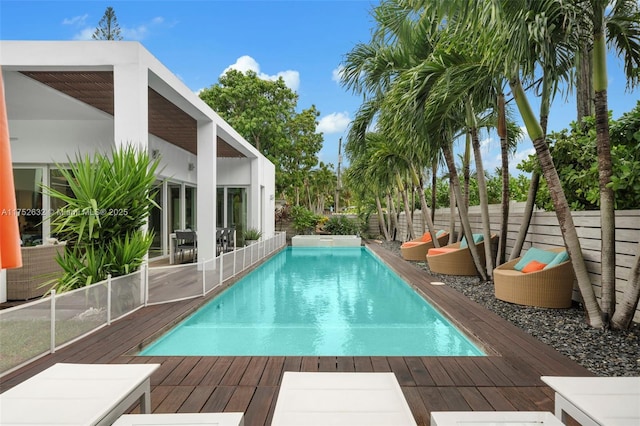 view of pool featuring a fenced backyard, a wooden deck, and a fenced in pool