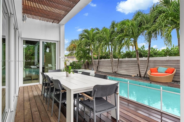 wooden terrace with a fenced in pool, outdoor dining area, a fenced backyard, and a pergola