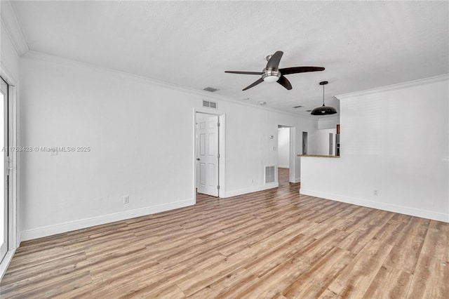 empty room featuring light wood finished floors, visible vents, and ornamental molding