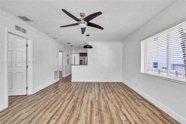 unfurnished living room featuring light wood-style floors, visible vents, and ornamental molding