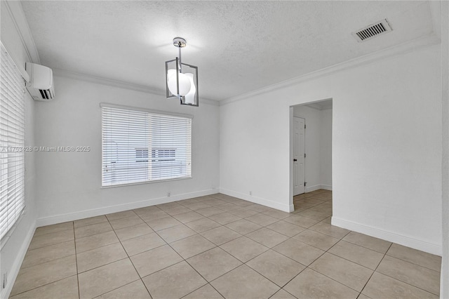 spare room with ornamental molding, a wall mounted air conditioner, visible vents, and a textured ceiling