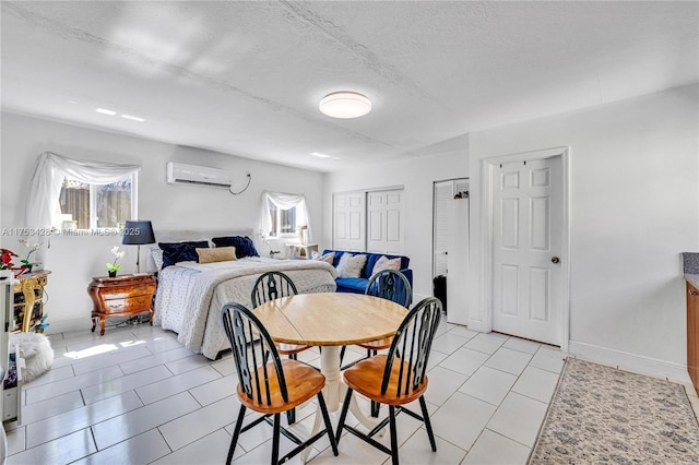 dining space featuring a wall unit AC, a textured ceiling, baseboards, and light tile patterned floors