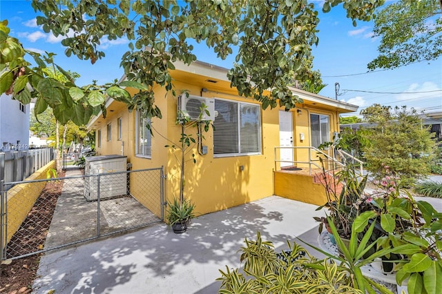 view of front of house with fence private yard, a gate, a patio, and stucco siding