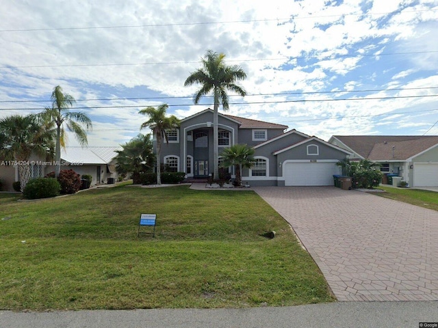 view of front facade featuring a garage, a front yard, decorative driveway, and stucco siding