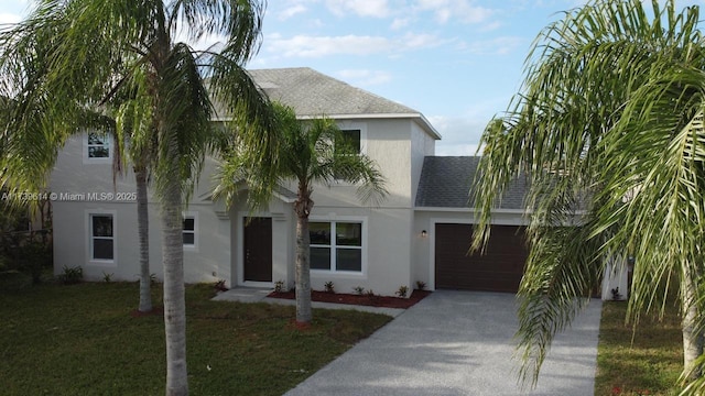 view of front facade featuring a garage, a shingled roof, driveway, stucco siding, and a front lawn