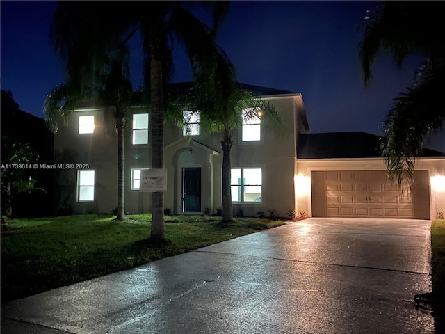 view of front facade with concrete driveway, a lawn, an attached garage, and stucco siding