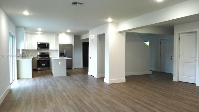 kitchen with visible vents, white cabinetry, open floor plan, light countertops, and appliances with stainless steel finishes