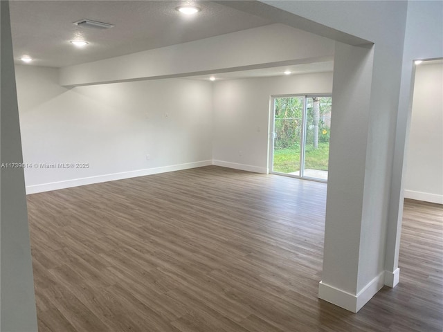 unfurnished room with baseboards, dark wood finished floors, and recessed lighting