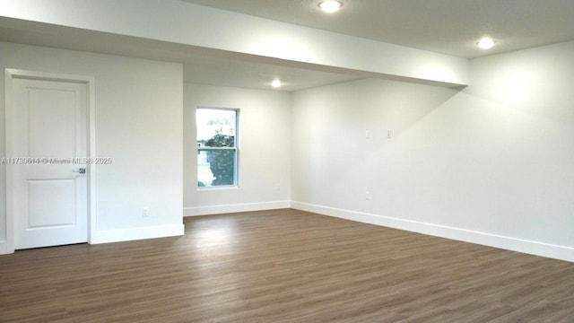 below grade area featuring recessed lighting, dark wood finished floors, and baseboards