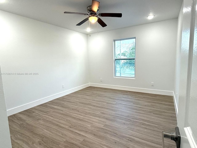 unfurnished room with ceiling fan, baseboards, and wood finished floors