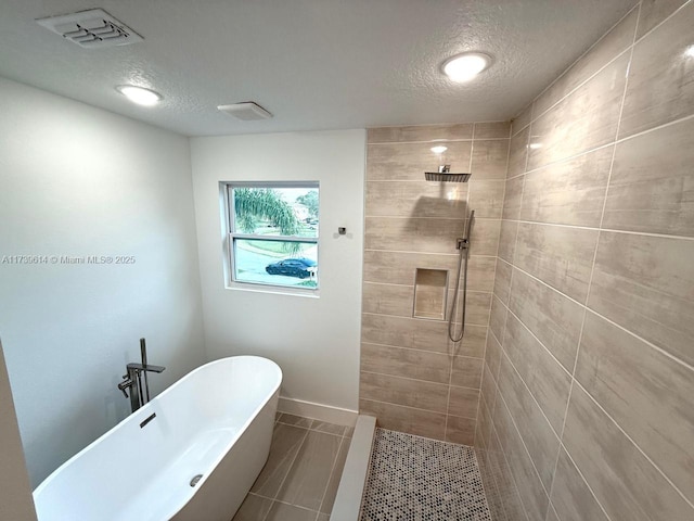 full bathroom featuring a soaking tub, visible vents, a textured ceiling, tiled shower, and baseboards