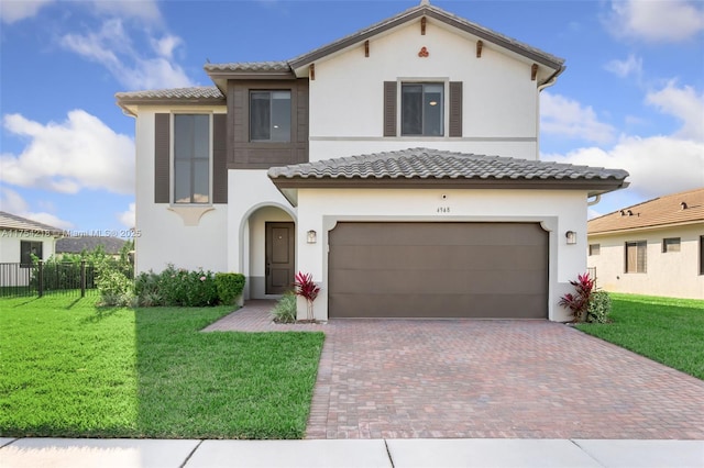 mediterranean / spanish house featuring a front yard, decorative driveway, and stucco siding