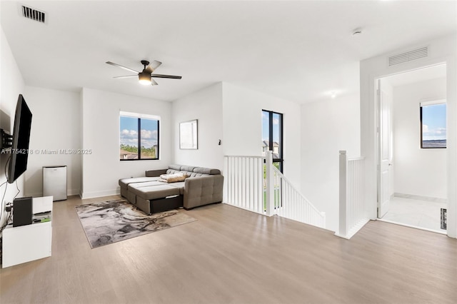 living room featuring wood finished floors, visible vents, and baseboards