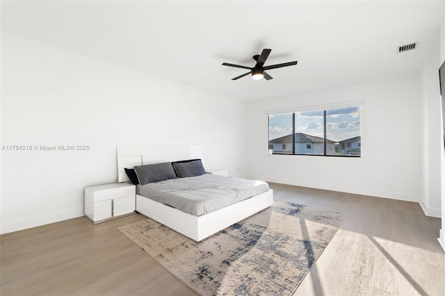 bedroom with visible vents, ceiling fan, baseboards, and wood finished floors