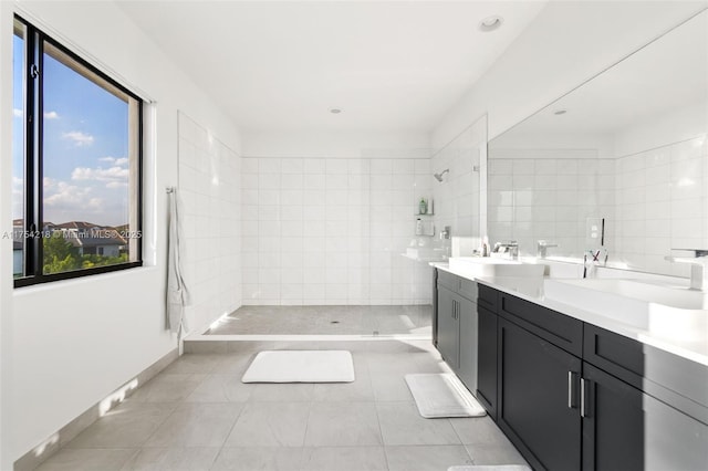 full bathroom with a walk in shower, double vanity, tile patterned flooring, and a sink