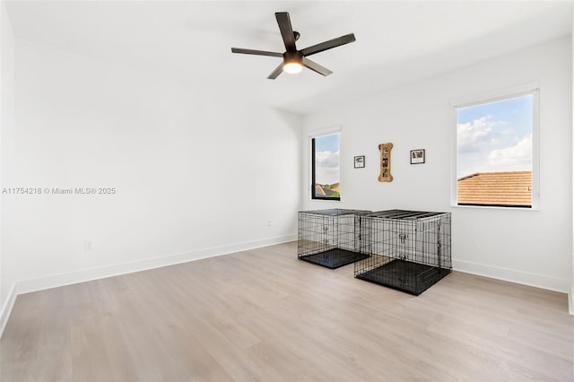 living area featuring ceiling fan, wood finished floors, and baseboards