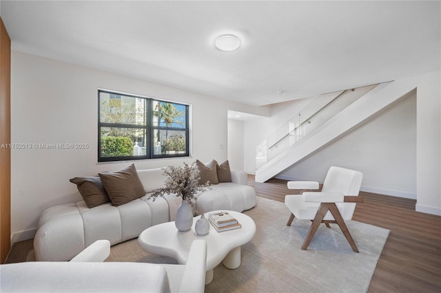 living room with baseboards, stairway, and wood finished floors