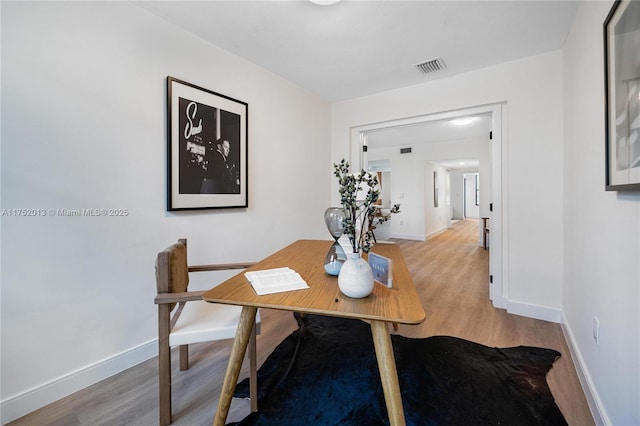 dining room with visible vents, baseboards, and wood finished floors