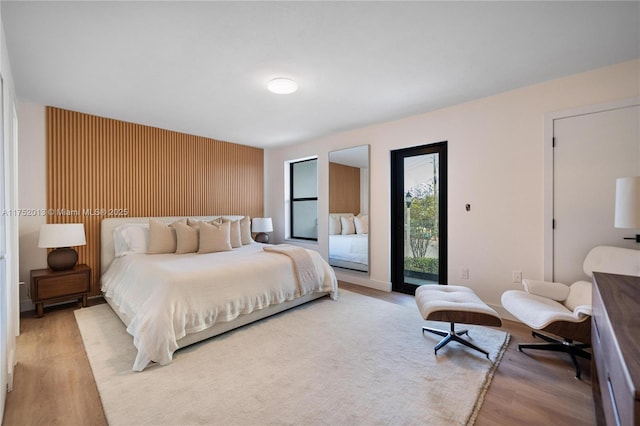 bedroom with light wood-type flooring and access to exterior