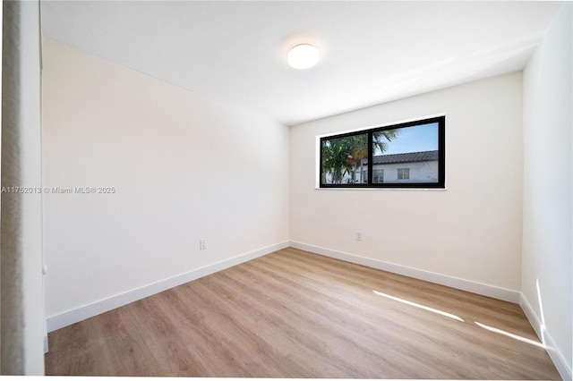 unfurnished room with light wood-style flooring and baseboards