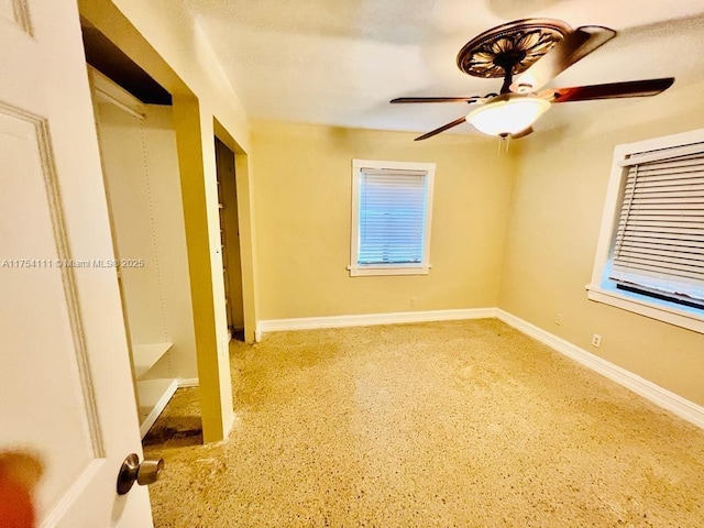 spare room with plenty of natural light, ceiling fan, and baseboards