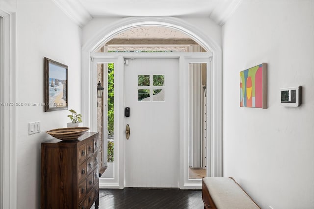 entrance foyer featuring dark wood-type flooring and crown molding