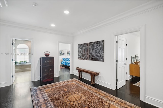 bedroom with baseboards, dark wood finished floors, ensuite bath, ornamental molding, and recessed lighting