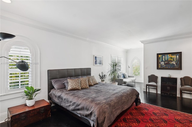 bedroom with baseboards, wood finished floors, and crown molding