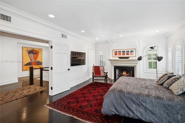 bedroom featuring wood finished floors, visible vents, and crown molding