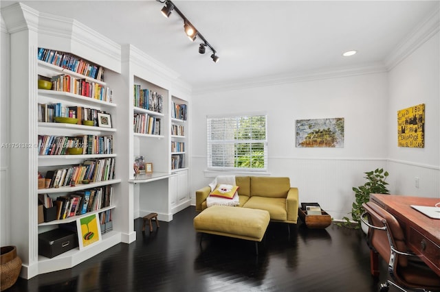 living area with a wainscoted wall, dark wood finished floors, and crown molding