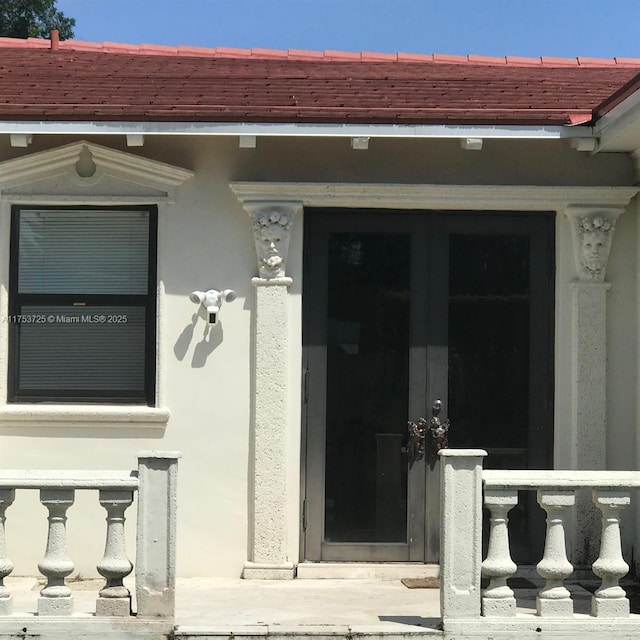 view of exterior entry with stucco siding and french doors