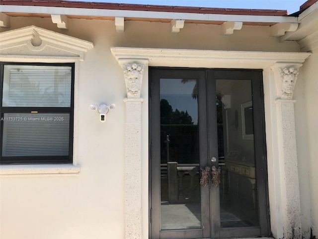 doorway to property featuring french doors and stucco siding