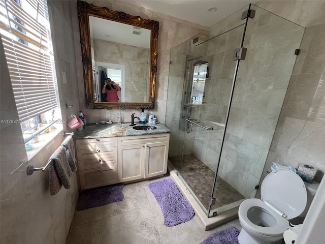 full bath with a shower stall, toilet, tile walls, vanity, and tile patterned flooring