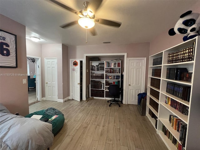 bedroom with visible vents, ceiling fan, wood finished floors, and baseboards
