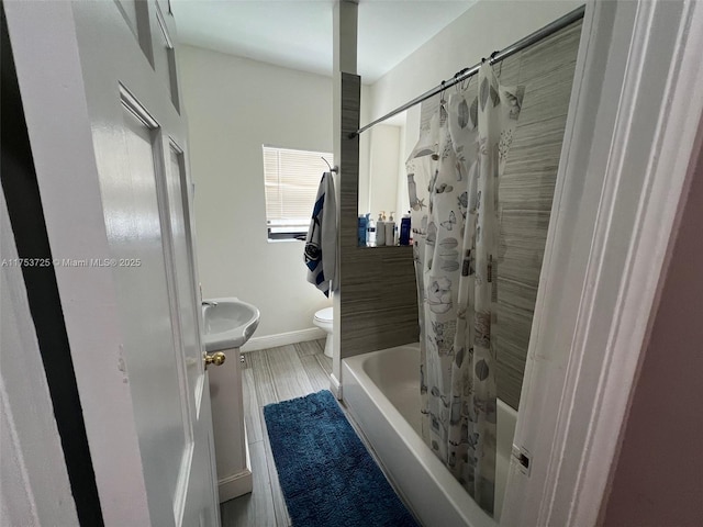full bathroom with toilet, a sink, shower / bathtub combination with curtain, and baseboards