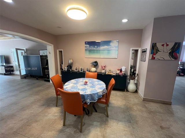 dining space with recessed lighting, arched walkways, and baseboards