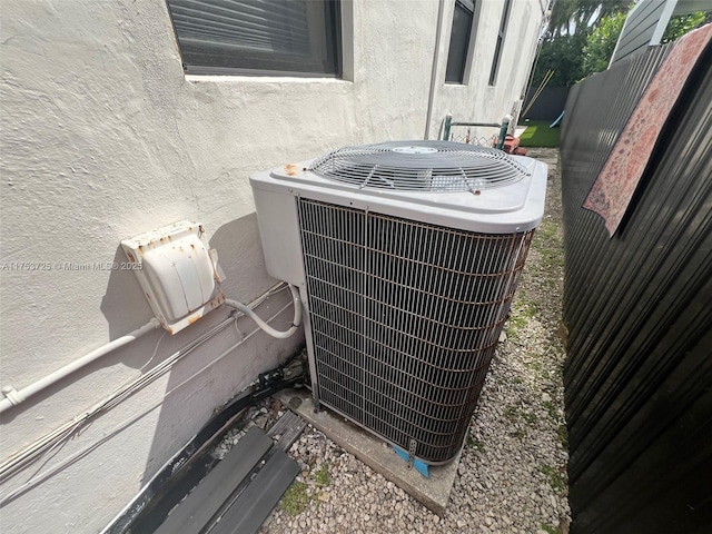 exterior details with fence, central AC unit, and stucco siding