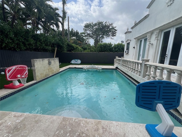 view of swimming pool featuring a fenced in pool, french doors, and a fenced backyard