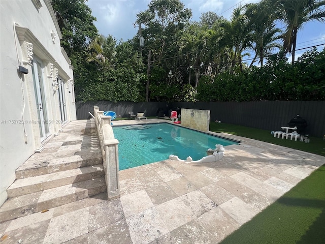 view of swimming pool featuring a fenced in pool, a fenced backyard, and a patio area