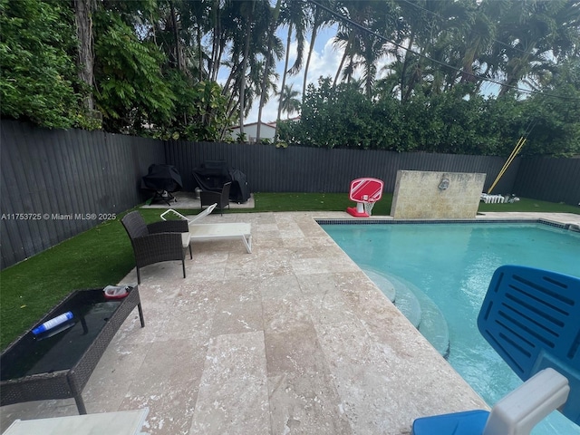 view of pool featuring a fenced backyard, a fenced in pool, and a patio area