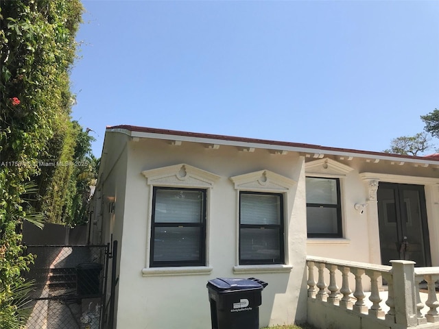 view of front of house with stucco siding and fence