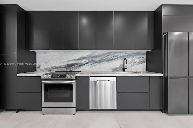 kitchen featuring modern cabinets, stainless steel appliances, a sink, and gray cabinetry