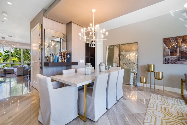 dining space with baseboards and a chandelier