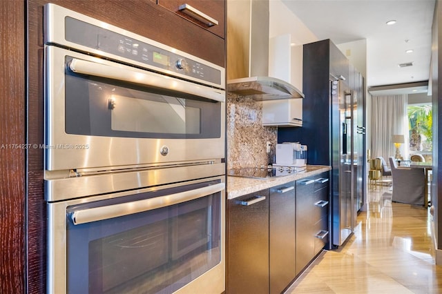 kitchen featuring backsplash, double oven, wall chimney range hood, modern cabinets, and black electric cooktop